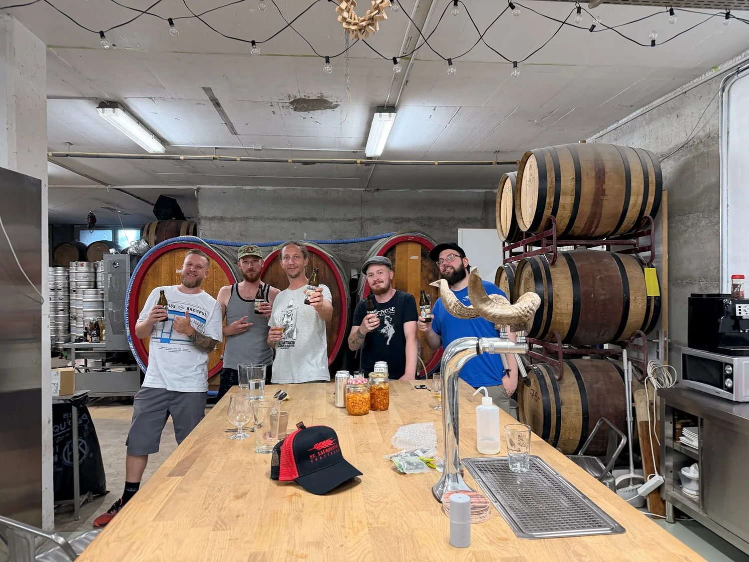 Sandro with the L’Apaisée collaboration group at the Geneva brewery among wooden barrels