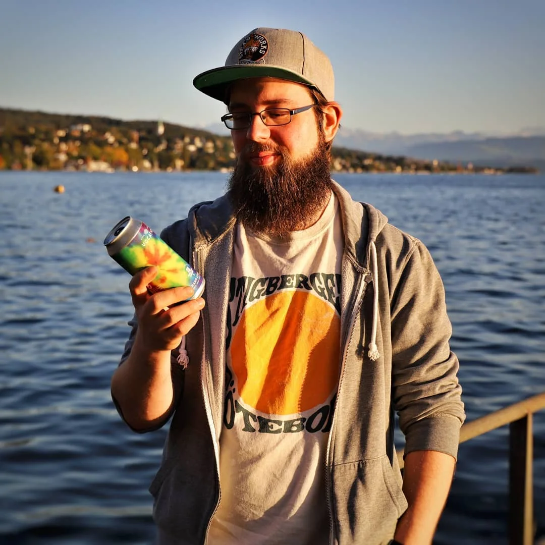 Sandro looking at a colorful craft beer can by Lake Zurich