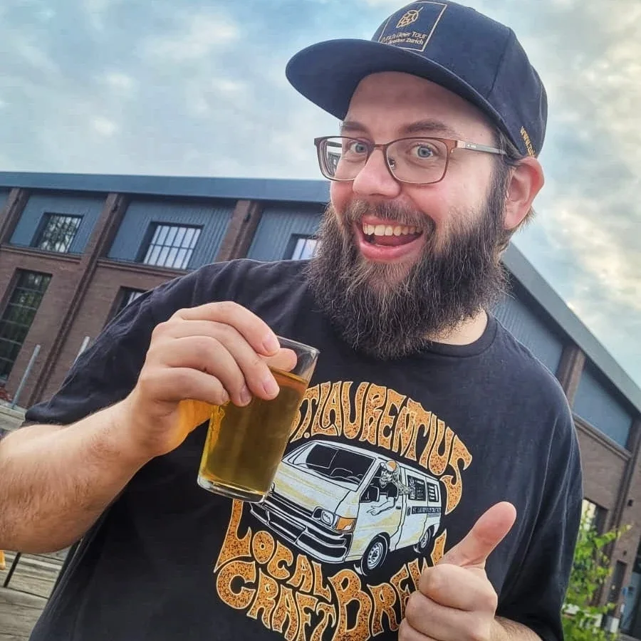 Sandro Wirth smiling directly at the camera and holding a beer
